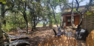a yard with chairs and a house with trees at Escapades en Ventoux in Venasque