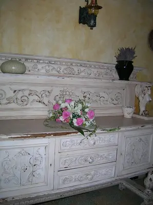 a white dresser with a bouquet of flowers on it at Le Mas des Baux in Bédoin