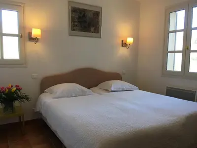a bedroom with a white bed with two pillows at La Garance in Bédoin