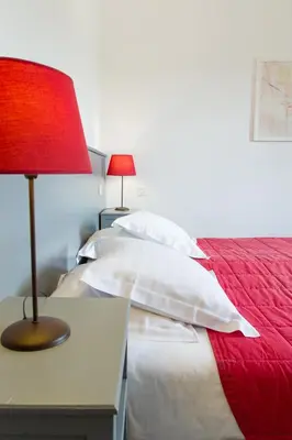 a bedroom with two beds and a red lamp on a table at La Garance in Bédoin