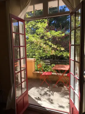 an open door leading to a patio with a table and a table at B&B Villa Roumanille in Aix-en-Provence