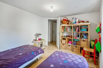 a bedroom with a purple bed and a book shelf at Charmante Maison à Bonnieux avec Terrasse et Vue sur le Jardin in Bonnieux