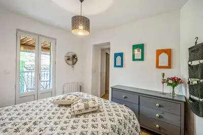 a bedroom with a bed and a dresser and a window at Charmante Maison à Bonnieux avec Terrasse et Vue sur le Jardin in Bonnieux