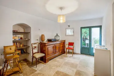a living room with a table and chairs and a book shelf at Charmante Maison à Bonnieux avec Terrasse et Vue sur le Jardin in Bonnieux