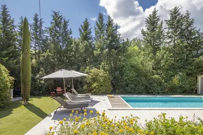 a backyard with a swimming pool and an umbrella at Villa Enzo in Orgon