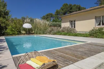 a swimming pool with a basket of towels next to a house at Villa Enzo in Orgon