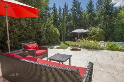 a patio with chairs and an umbrella and a table at Villa Enzo in Orgon