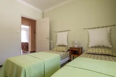 a white room with two beds and a window at Villa Enzo in Orgon