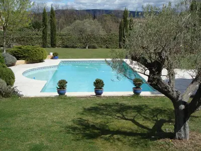 a swimming pool with potted plants in a yard at La Guéritaulde in La Tour-dʼAigues