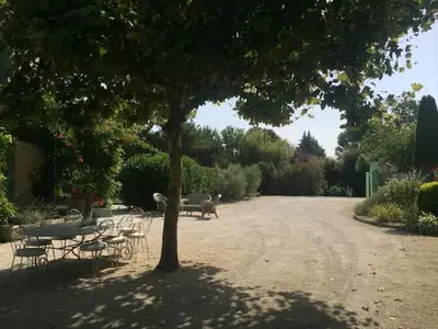 a patio with wicker furniture and a table and chairs at Villa Neville in Châteaurenard