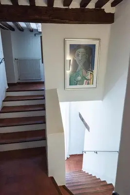 a stairway with a painting of a woman on the wall at Domaine de Saint Pons in Villars