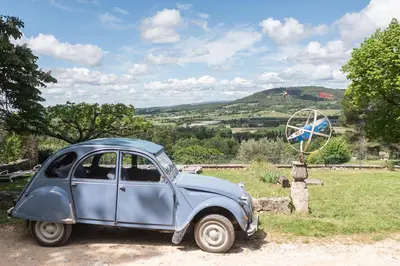 an old blue car parked in a field at Domaine de Saint Pons in Villars