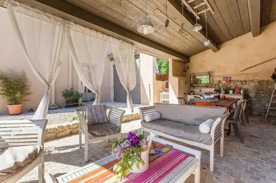 a patio with a couch and chairs and a table at Bastide de Fanny in Rognes