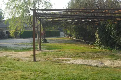 a wooden pergola in a yard with a pathway at Lou mas li Pitchoun 