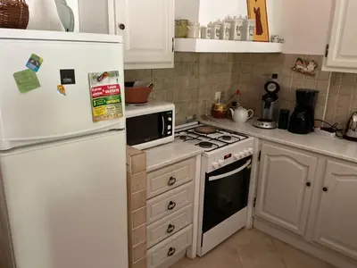 a kitchen with a white refrigerator and a stove at Les Cigales in Saint-Andiol