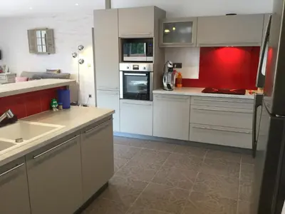 a kitchen with white cabinets and a red wall at Beautiful provencal vacation rental in L'Isle sur la Sorgue in LʼIsle-sur-la-Sorgue