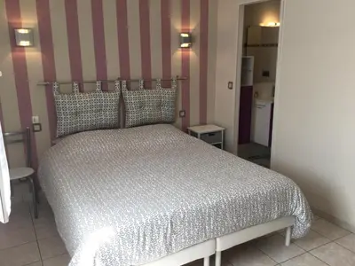a bedroom with a bed with a striped wall at Beautiful provencal vacation rental in L'Isle sur la Sorgue in LʼIsle-sur-la-Sorgue