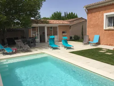 a swimming pool with blue chairs and a table at Beautiful provencal vacation rental in L'Isle sur la Sorgue in LʼIsle-sur-la-Sorgue