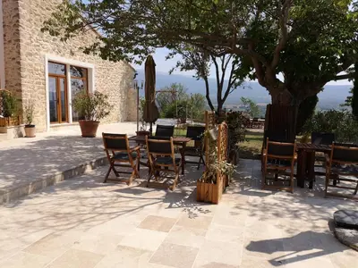 a patio with a table and chairs and a tree at La Bastide du Limon in Mormoiron