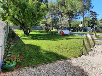 a yard with a fence and some flowers and trees at A pretty family house located in a tranquil area with a pretty view of the Luberon range. in Les Taillades