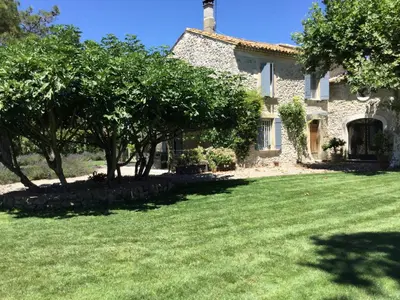 a stone house with trees in front of a yard at superb prestigious mas with pool in the countryside of caumont sur durance, close to avignon, sleeps 8 in Caumont-sur-Durance