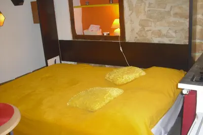 a yellow bed with two yellow pillows on it at Lou mas li Pitchoun 