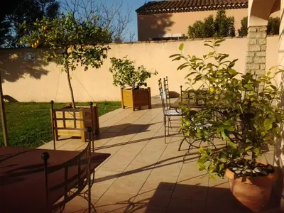 a patio with potted plants and a wall at fleur de garance in Le Thor