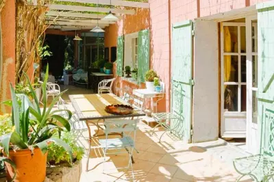 a patio with a table and chairs and plants at Le Domaine de Saint Veran in Orgon