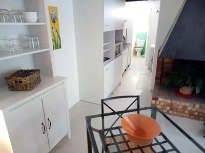 a kitchen with white cabinets and a table and a chair at Le Moulin Des Ocres in Apt
