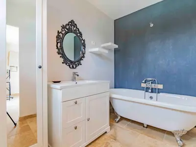 a bathroom with a tub and a sink and a mirror at Holiday Home L'Oliveraie by Interhome in Saint-Didier