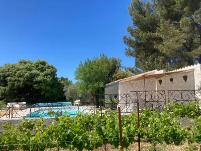 a view of a swimming pool behind a fence at LA RESPELIDANE in Caromb