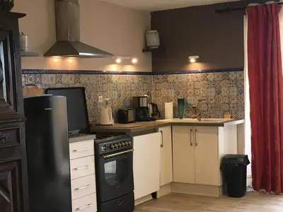 a kitchen with a stove and a refrigerator at LA RESPELIDANE in Caromb