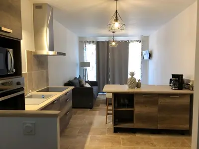 a kitchen and living room with a table and a couch at Mas Eléhis Gîtes en Provence in Pernes-les-Fontaines