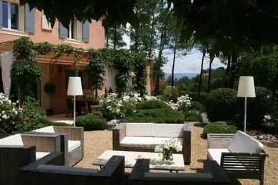 a garden with couches and tables and flowers at Les Oursillons in Roussillon