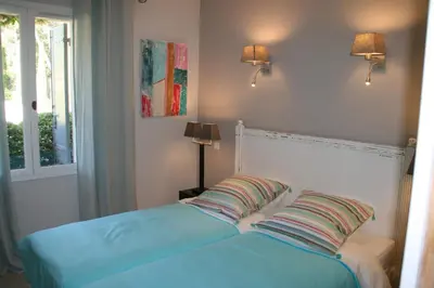 a bed with two pillows sitting next to a window at Les Oursillons in Roussillon