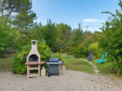 a backyard with a stove and a grill at Modern holiday home with private pool in Lambesc