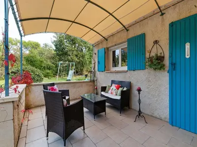 a patio with blue doors and chairs and a table at Modern holiday home with private pool in Lambesc