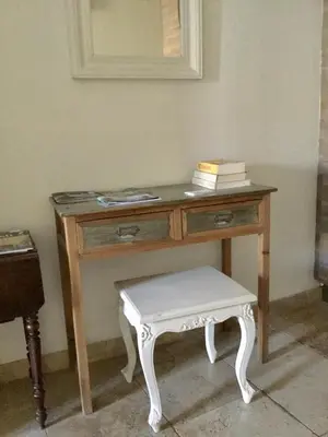 a wooden desk with a stool and a mirror at Un Coin De Luberon in LʼIsle-sur-la-Sorgue