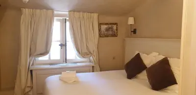 a bedroom with a white bed with a window at Les Quatre Dauphins in Aix-en-Provence