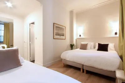 a hotel room with two beds and a window at Les Quatre Dauphins in Aix-en-Provence