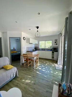 a living room with a table and a kitchen at La petite maison avec piscine face au Luberon in Robion en Luberon