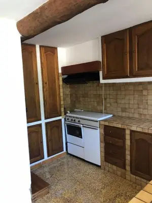 a kitchen with a white stove and wooden cabinets at Fontaine-de-Vaucluse : maison avec vues in Fontaine-de-Vaucluse