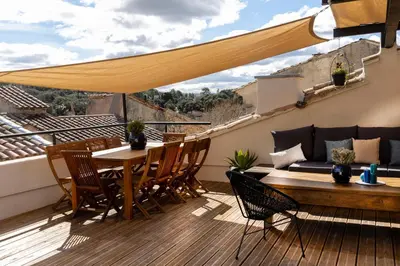 a patio with a table and chairs on a deck at La terrasse de Tiss in Bédoin