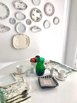 a table with plates and dishes on a wall at Petit Rêve in LʼIsle-sur-la-Sorgue