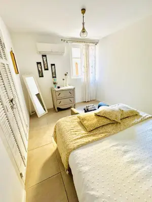 a bedroom with a bed and a dresser and a window at Petit Rêve in LʼIsle-sur-la-Sorgue