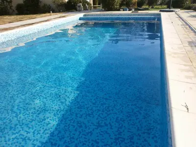 a large swimming pool with blue water at Pervenches in Jonquerettes