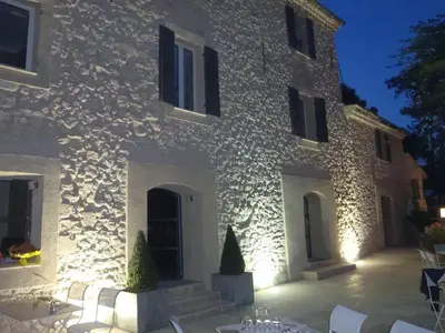 a building with tables and chairs in front of it at La Bastide de Venelles in Venelles