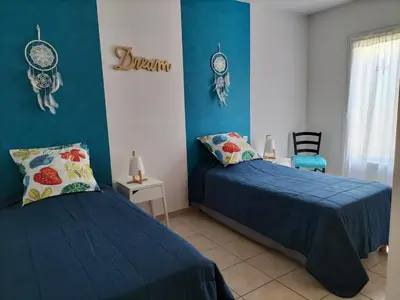 two beds in a room with blue walls at Villa Zénitude in Cabannes