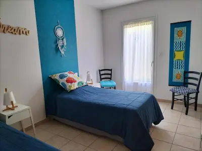 a bedroom with a bed with a blue comforter at Villa Zénitude in Cabannes