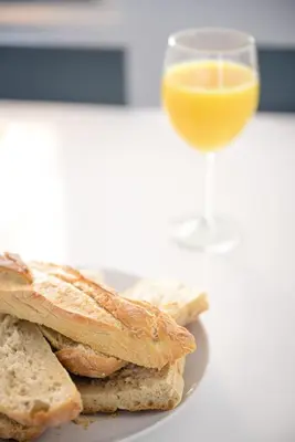 a plate of bread and a glass of orange juice at chez nico in Bédoin